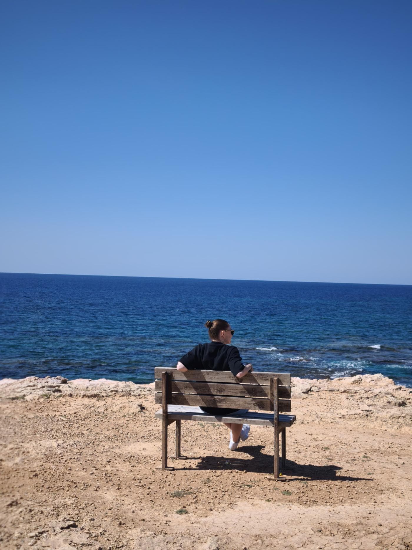 Marie auf einer Bank am Meer